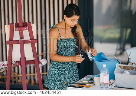 Young Beautiful Woman Squeezing Paint Tube In Art-class