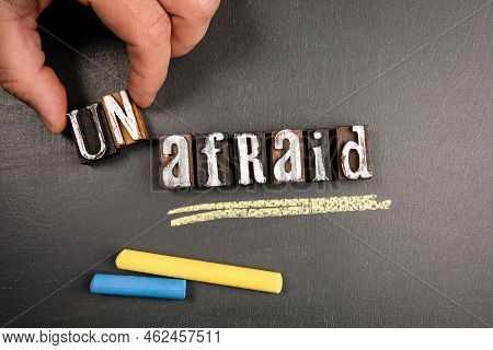 Unafraid And Afraid Concept. Wooden Alphabet Letters And Text On Blackboard