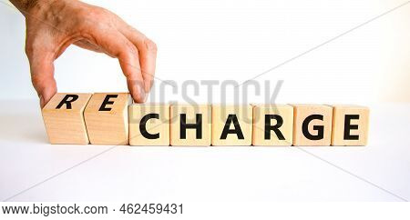 Charge Or Recharge Symbol. Businessman Turns Wooden Cubes And Changes The Word 'charge' To 'recharge