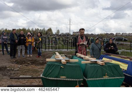 Bucha, Ukraine, 04-10-2022: Father Blesses The Coffins Of The Reservist Soldiers Who Died During The