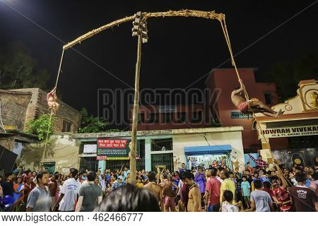 Howrah, West Bengal,india - 15th April 2019: Two Hindu Devotees Are Hanging From Pole In Air, At Nig