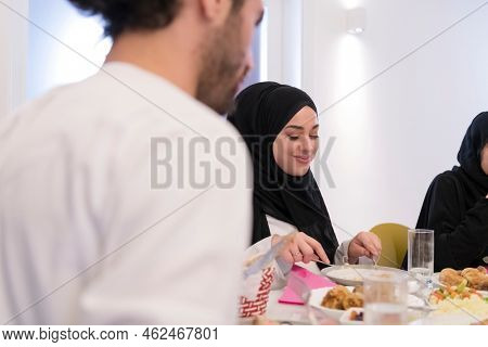 Muslim family making iftar dua to break fasting during Ramadan.
