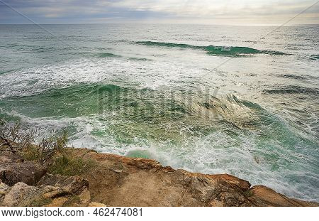 Churning, Turbulent Water Breaking Over Rocks At High Tide Along A Rocky Coastline On The Sunshine C
