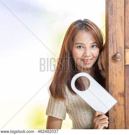 Asian Cute Woman Hold Door Tag And Smile In Front Of Wood Door At Outdoor Field.