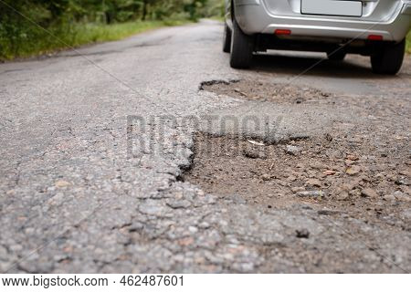 Car Driving On A Bad Road With A Lot Of Potholes, Chuckholes