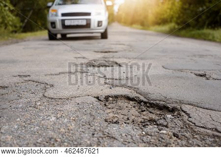 Countryside Road In Terrible Condition With Modern Car Driving Through