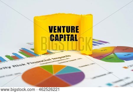 Business Concept. Against The Background Of Graphs And Charts, A Yellow Paper Plate With The Inscrip