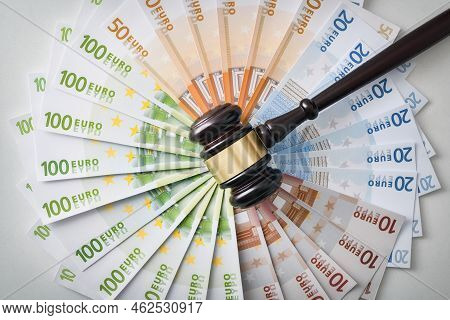 Concept Of Financial Judgment With Judge's Gavel On A Pile Of Banknotes In A Circle Top View