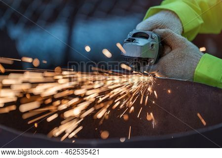Close Up Hand Of Industrial Worker Using Angle Grinder And Cutting A Metal Tube. Worker In Safety Un