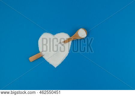 Collagen Powder Or Protein On Blue Background. Healthy Food Supplement. Powder Poured In Shape Of He