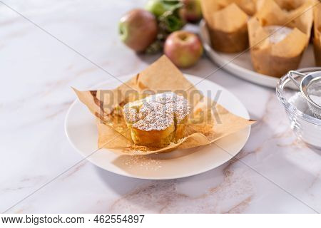 Eating Freshly Baked Apple Sharlotka Muffin Dusted With Powdered Sugar.