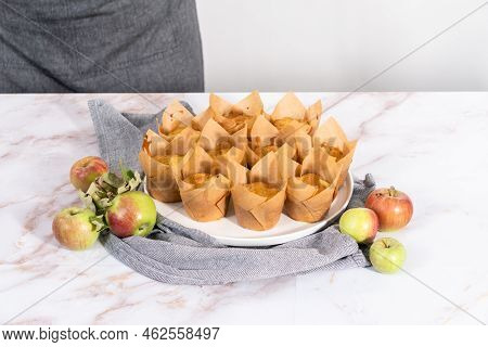 Garnishing Freshly Baked Apple Sharlotka Muffins Dusted With Powdered Sugar.