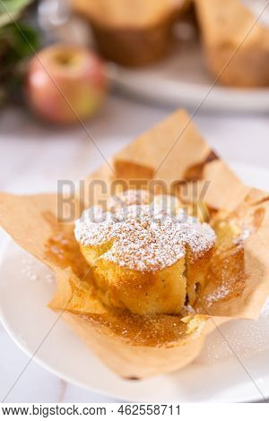 Eating Freshly Baked Apple Sharlotka Muffin Dusted With Powdered Sugar.