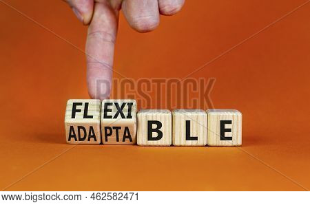 Adaptable Or Flexible Symbol. Businessman Turns Wooden Cubes And Changes The Word Adaptable To Flexi