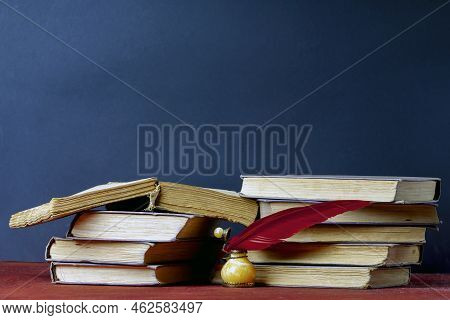 Amber Inkwell With Red Pen For Writing On The Background Of Old Books