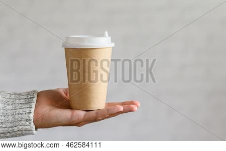 Disposable Paper Cup In A Male Hand On A Light Gray Background. Copy Space