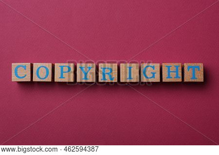 Wooden Cubes With Word Copyright On Dark Pink Background, Flat Lay. Plagiarism Concept