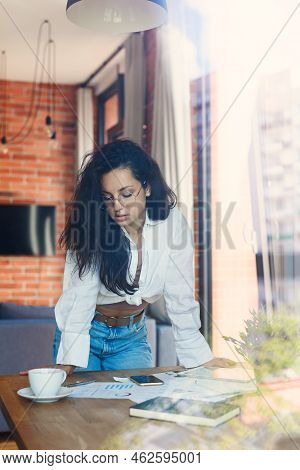 Young Beautiful Smiling Woman At Eyeglasses With Tablet Pc And Business Documens Sitting On Table At