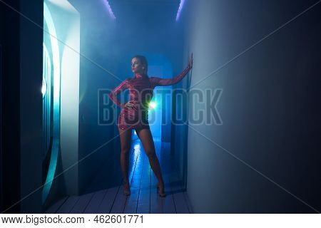 A Fashionable Photo Shoot With Tinted Blue, A Young Beautiful Model In A Scarlet Dress, In A Mysteri