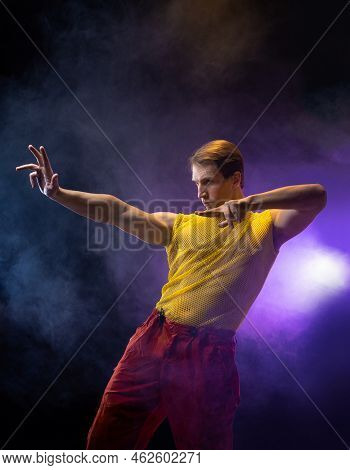 A Young Muscular Man In A Bright Outfit Poses In A Pretentious Pose, Style And Grotesque. Attractive