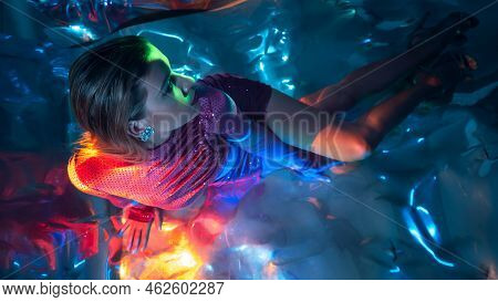 Glamorous Portrait Of A Young Beautiful Blonde In A Stylish Scarlet Short Dress, Sitting On The Floo