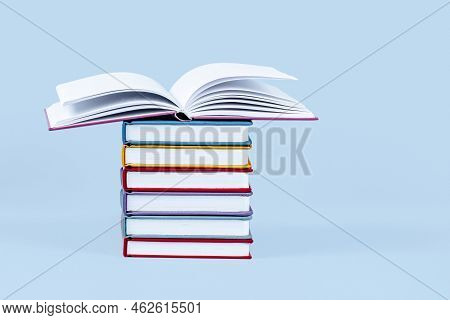 Stack Of Books On Light Blue Background. Front View, Copy Space Fot Text Or Product. Education, Back