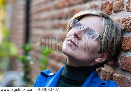 Portrait Of An Attractive Thirty Year Old White Woman Posing Against A Brick Wall, Brussels