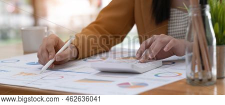 Business Woman Using Calculator To Calculate Financial Report, Working At Office With Laptop Compute