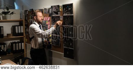 Private Detective Working In The Office Looking At The Evidence Board At Night, Investigator Investi
