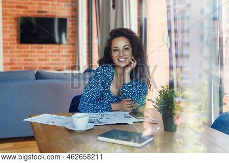 Young Beautiful Smiling Woman At Eyeglasses With Tablet Pc And Business Documens Sitting On Table At