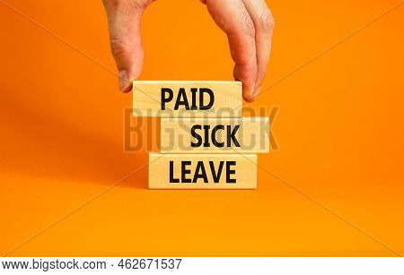 Paid Sick Leave Symbol. Concept Words Paid Sick Leave On Wooden Blocks. Doctor Hand. Beautiful Orang
