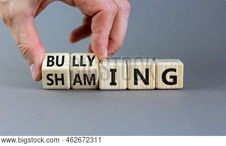 Shaming And Bullying Symbol. Concept Words Shaming And Bullying On Wooden Cubes. Businessman Hand. B