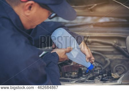 Car Mechanic Man Hands Pouring Deionized Purified Distilled Water For Car Battery Mechanical Service