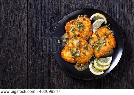Chicken Piccata Of Parmesan Breaded Seared Chicken Breasts With Lemon Butter Caper Sauce On Black Pl