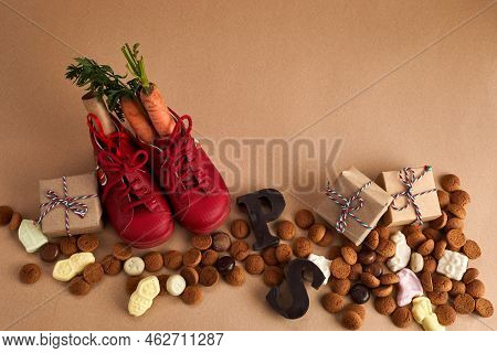 Saint Nicholas - Sinterklaas Day With Shoe, Carrot And Traditional Sweets On Caramel Background