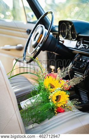 Vintage Wedding Car With Lovely Wedding Bouquet Full Of Roses And Sunflowers