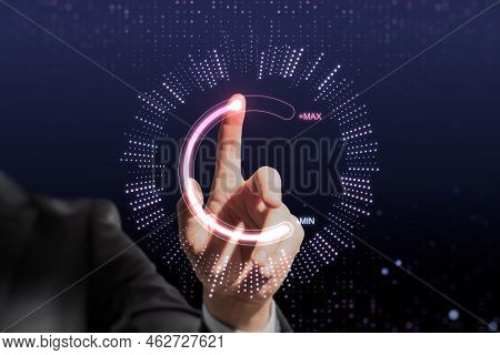 Close Up Of Businessman Hand Pointing At Abstract Glowing Max And Min Scale Hologram On Dark Backgro