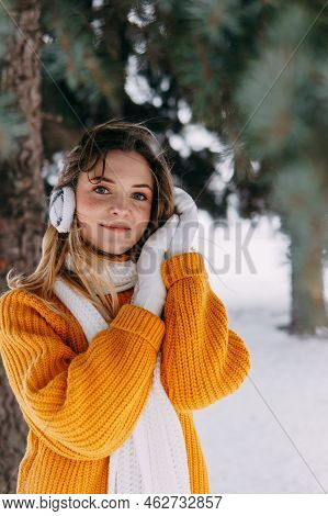Teen Blonde In A Yellow Sweater Outside In Winter. A Teenage Girl On A Walk In Winter Clothes In A S