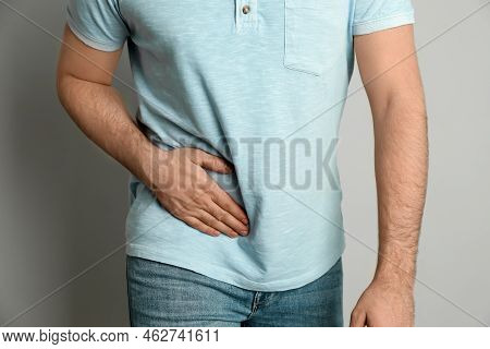 Man Suffering From Acute Appendicitis On Light Grey Background, Closeup