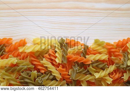 Heap Of Vegeroni Spiral Shaped Three-color Fusilli Pasta On Wooden Background