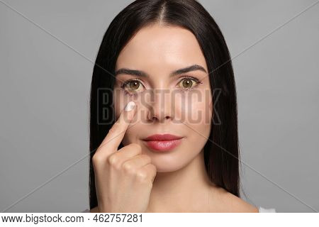 Woman Checking Her Health Condition On Grey Background. Yellow Eyes As Symptom Of Problems With Live
