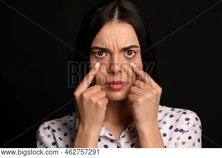 Woman Checking Her Health Condition On Black Background. Yellow Eyes As Symptom Of Problems With Liv