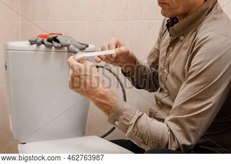 Plumber With A Set Of Plumbing Tools And Fum Tape Repairs The Flush Tank In The Toilet