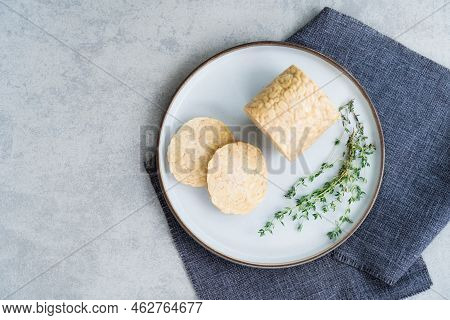 Top View Raw Tempeh Or Tempeh, Made Of Fermented Soybean Seeds. Tempeh Slices On Plate With Herbs. S