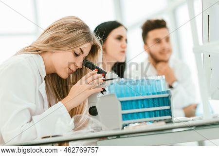 Close Up.a Modern Female Scientist Looks Into A Microscope In A