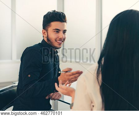 Rear View.business Couple Discussing Financial Data While Sitti