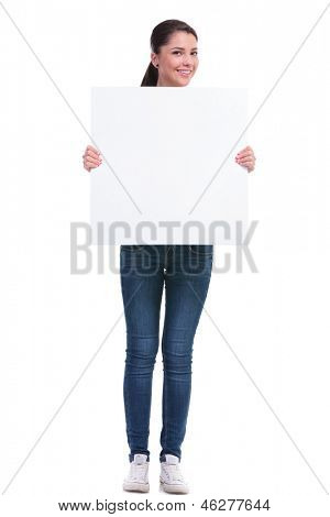 voth ile boş bir paneli ellerini tutarak ve t gülümseyen sıradan bir genç kadın tam uzunlukta resim