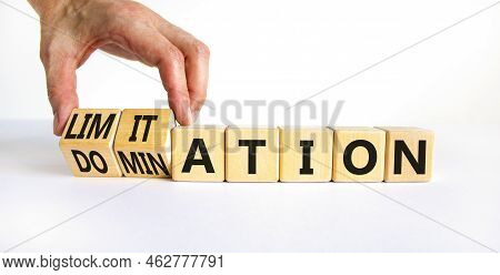Domination Or Limitation Symbol. Businessman Turns Cubes, Changes The Word Domination To Limitation.
