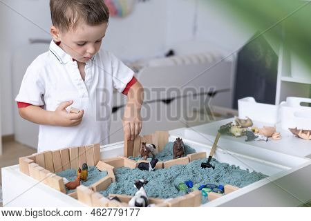 Cute Baby Boy Playing Sensory Box Kinetic Sand Table With Farm Animals