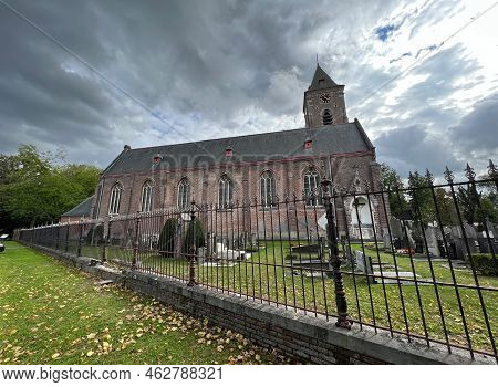 Bellem, Flandres, Belgium 09 18 2022 : Wide Anlge View On A Catholic Chruch And Cemetary Against A C
